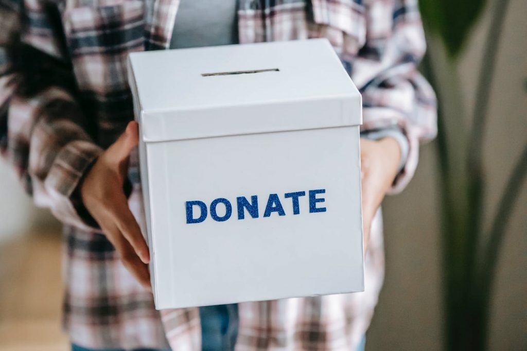 A man holding up a donation box.