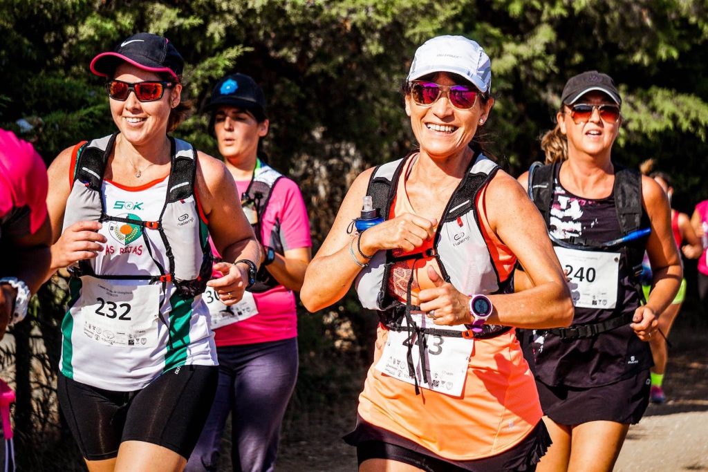A group of women smiling as they take part in a fun run.
